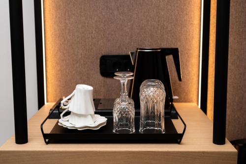 a black tray with two glass vases and a blender at Neapolis 21 Suites, Premium Key Collection in Skiathos Town