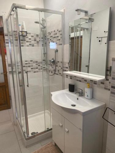 a bathroom with a glass shower and a sink at Sweet Home Sara in Ovada