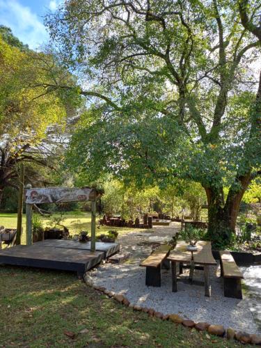 a picnic area with benches and a canopy in a park at Holt Hill in Plettenberg Bay