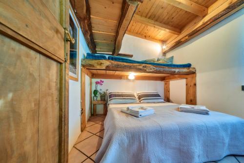 ein Schlafzimmer mit einem Bett in einem Zimmer mit Holzdecken in der Unterkunft piccola casa naturale sul lago in Varenna