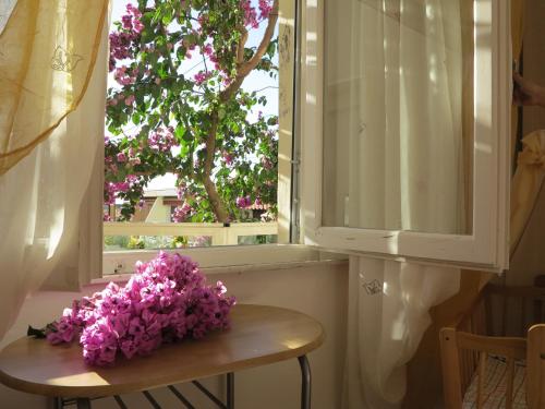 a bunch of purple flowers sitting on a table in front of a window at Casamare Hotel in San Vincenzo