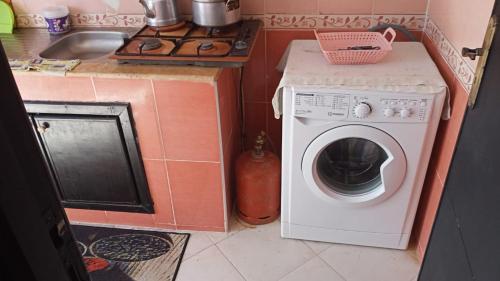 a kitchen with a washing machine and a sink at bel appartement dans une residence calme in Martil