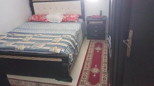 a small bedroom with a bed and a night stand at bel appartement dans une residence calme in Martil