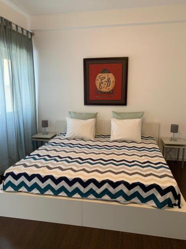 a bedroom with a large bed with a striped blanket at Charming apartment in Principle Real in Lisbon