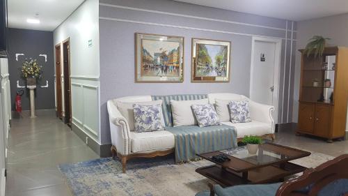 a living room with a white couch and a table at Antonio's Hotel e Spa - Airport in Brasilia
