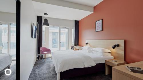 a bedroom with a large bed with orange walls at Center Hotels Laugavegur in Reykjavík