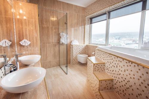 a bathroom with two sinks and a shower and a tub at Hotel Hafnia in Tórshavn