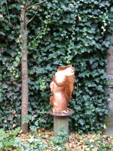 a statue of a squirrel sitting on a pole in front of a hedge at B&B Pakhuis Emden in Groningen