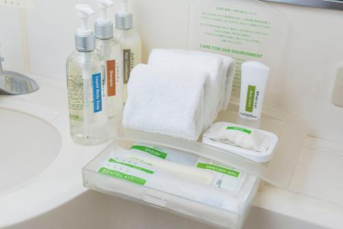 a shelf in a bathroom with toiletries and towels at ANA Holiday Inn Sapporo Susukino, an IHG Hotel in Sapporo