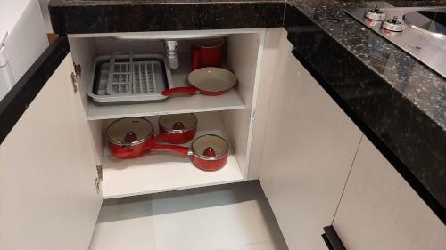 an overhead view of a kitchen cupboard with pots and pans at Apartamento Mania in Vitória