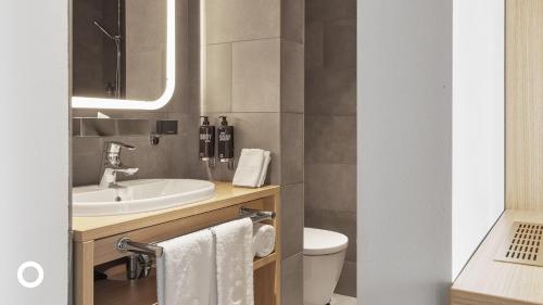 a bathroom with a sink and a toilet and a mirror at Center Hotels Laugavegur in Reykjavík