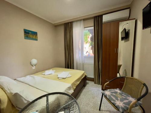 ein Hotelzimmer mit einem Bett, einem Stuhl und einem Fenster in der Unterkunft Hotel Maria in Tbilisi City