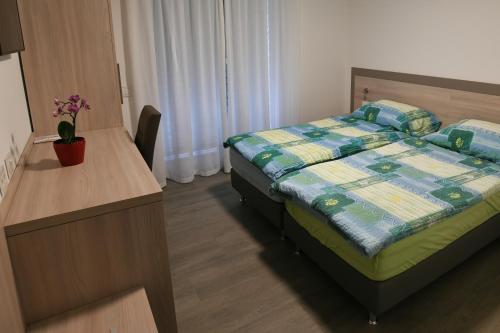 a bedroom with a bed and a desk with apared at Motel Afia in Cama