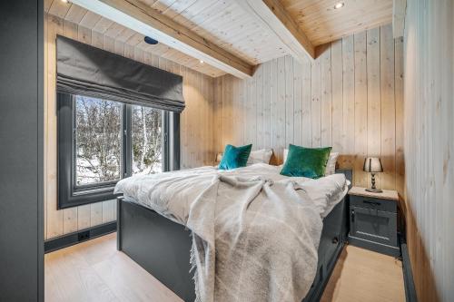 sypialnia z dużym łóżkiem i oknem w obiekcie NEW LUXUARY Cabin with perfect location on Geilo. w mieście Flatåker