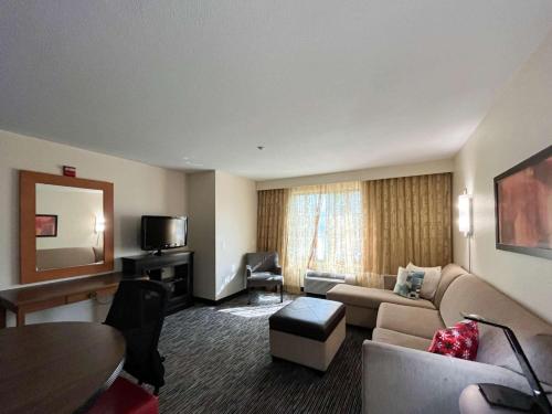 a hotel room with a couch and a table and a television at Studio 6 Carlsbad CA in Carlsbad