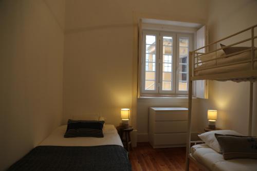 sypialnia z 2 łóżkami piętrowymi i oknem w obiekcie Stunning Apartment Marquês de Pombal w Lizbonie