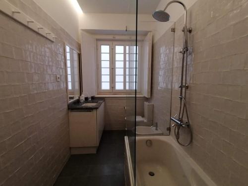 een badkamer met een bad, een wastafel en een douche bij Stunning Apartment Marquês de Pombal in Lissabon