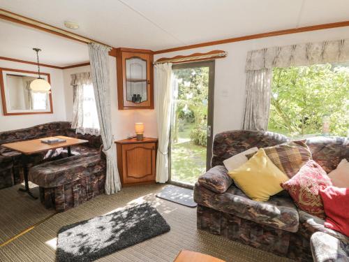 a living room with a couch and a table at Fron Dderw Caravan in Holyhead