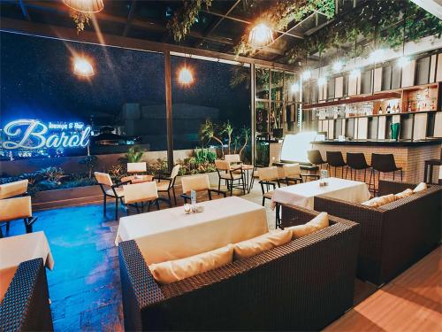 a restaurant with tables and chairs and a bar at Best Western The Lagoon Hotel in Manado