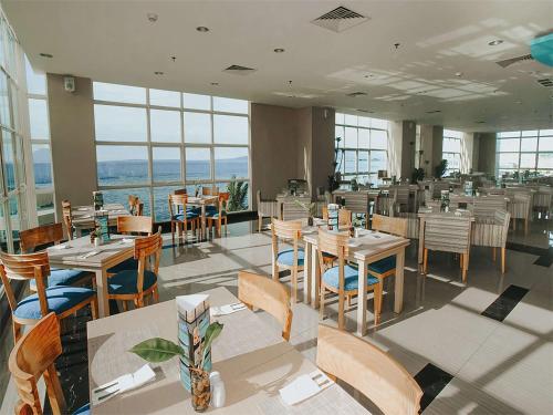 a restaurant with tables and chairs and windows at Best Western The Lagoon Hotel in Manado