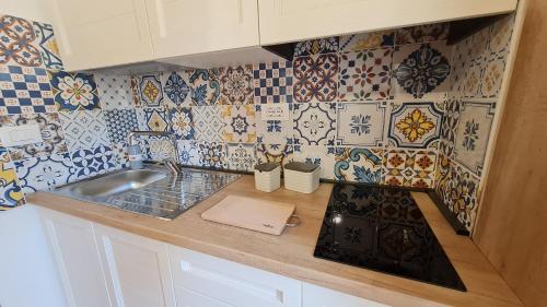 a kitchen with a sink and tiles on the wall at Casa Ruicella in Crotone