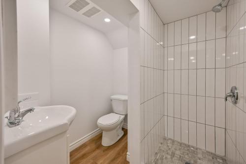a white bathroom with a toilet and a sink at 1 Bedroom Lower Level Suite in Burlington -The Jacob at Bellwood in Burlington