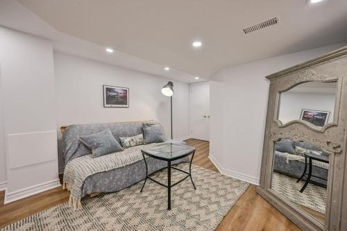 a living room with a couch and a mirror at 1 Bedroom Lower Level Suite in Burlington -The Jacob at Bellwood in Burlington