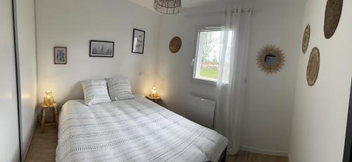 a white bedroom with a bed and a window at Maison neuve entre Bassin d'Arcachon et Landes in Le Muret