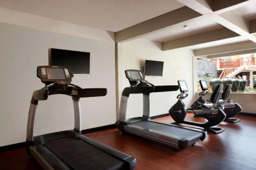 a gym with three cardio machines in a room at Best Western Premier Agung Resort Ubud in Ubud