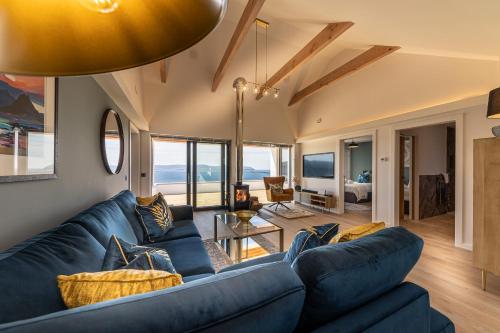a living room with a blue couch and a table at Tidal Reach Dunhallin in Hallin