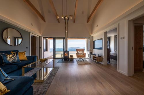 a living room with a blue couch and a table at Tidal Reach Dunhallin in Hallin