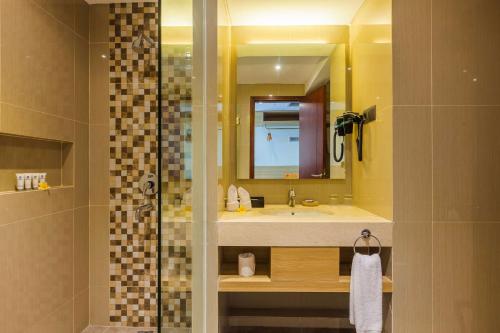 a bathroom with a sink and a shower with a mirror at Best Western Kamala Jimbaran in Jimbaran