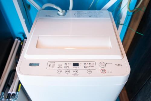 a white washing machine sitting in a room at ペットOK! JUNGLIA 15分! サウナ-プール-Private Villa 405 in Nakijin