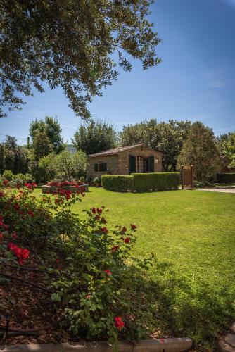 a house in a field with a yard with flowers at Relais La Corte dei Papi in Cortona
