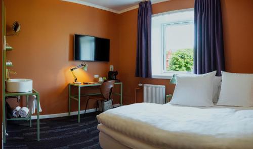a hotel room with a bed and a window at Hotel Hafnia in Tórshavn