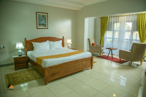a bedroom with a bed and a desk and chairs at CWEZI BY THE LAKE in Entebbe