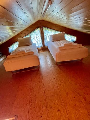two beds in a small room with windows at Ytri Vík in Hauganes