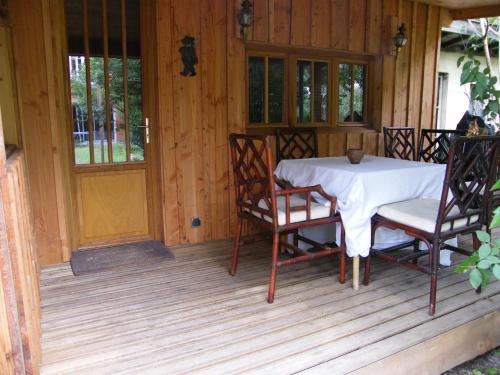 un porche de madera con mesa y sillas. en Particulier en Burdeos