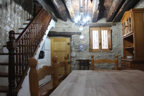 une salle à manger avec une table et un escalier dans l'établissement Casa Rústica en Villafranca del Cid con vistas a la montaña "Els Arenals", à Villafranca del Cid