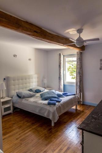 une chambre avec un lit et un ventilateur de plafond dans l'établissement Chambres d'Hôtes La Vigneronne, à Senouillac