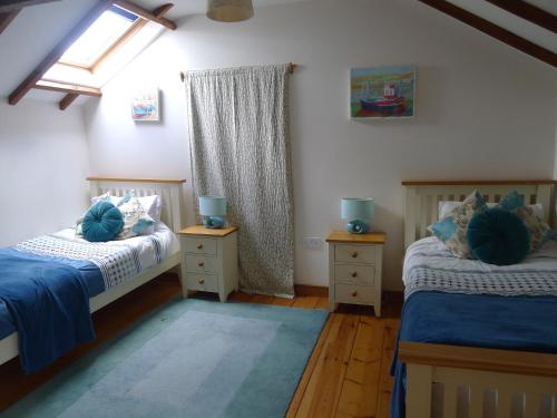 a bedroom with two beds and two night stands at Tuell Farm Cottages in Tavistock