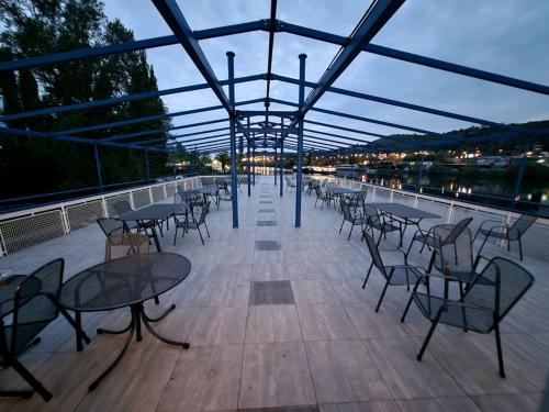 a patio with tables and chairs on a deck at Botel Racek in Prague