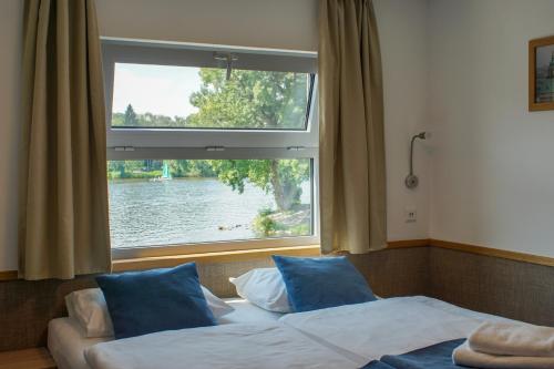 a bedroom with two beds and a large window at Botel Racek in Prague