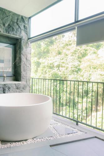 a bathroom with a tub and a large window at Zenubud in Ubud