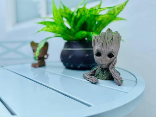 a small toy baby groot sitting on a table at Blue Eyes in Miami