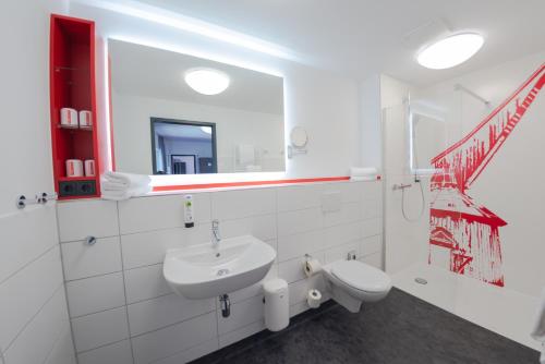 シュターデにあるhavenhostel Stade - Hotelの洗面台と鏡のある白いバスルーム