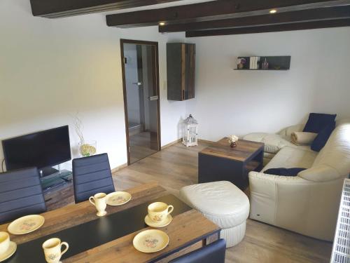 a living room with a couch and a table at Saechsische-Schweiz-Ferienhaus-Wohnung-2-mit-hervorragendem-Panoramablick-ueber-das-Elbtal in Königstein an der Elbe