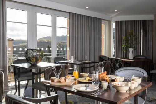 une salle à manger avec des tables et des chaises avec de la nourriture dans l'établissement Auberge de Clochemerle, Spa privatif & restaurant gastronomique, à Vaux-en-Beaujolais