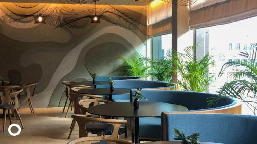 a restaurant with tables and chairs and plants at Center Hotels Laugavegur in Reykjav&iacute;k
