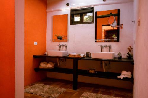 a bathroom with two sinks and a mirror at Posada la Serena in Villa de Leyva